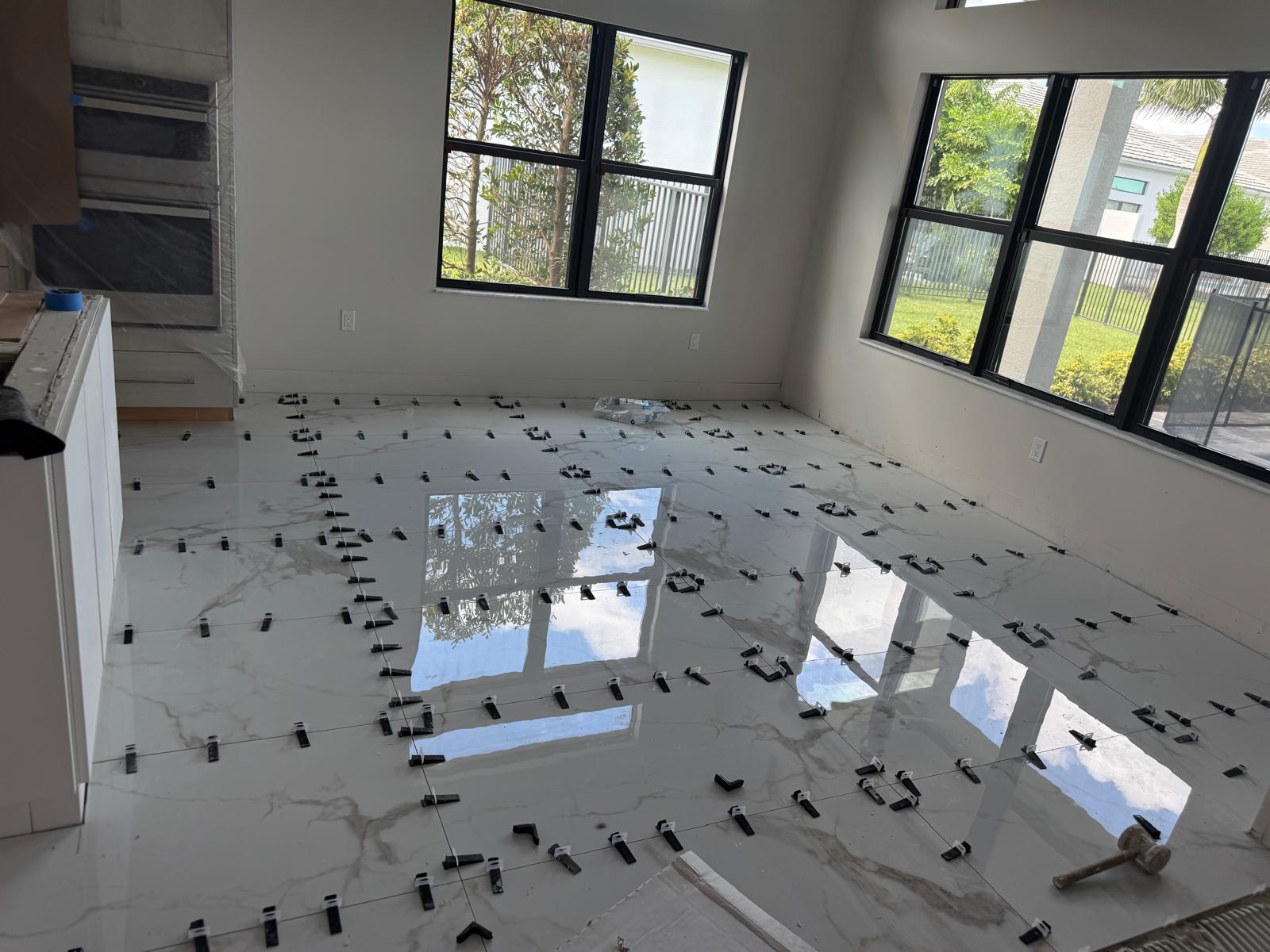 Instalación de baldosas de gran formato con niveladores en una habitación con ventanas