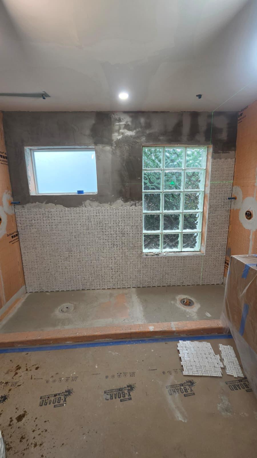 Zona de ducha en construcción con base expuesta y bañera